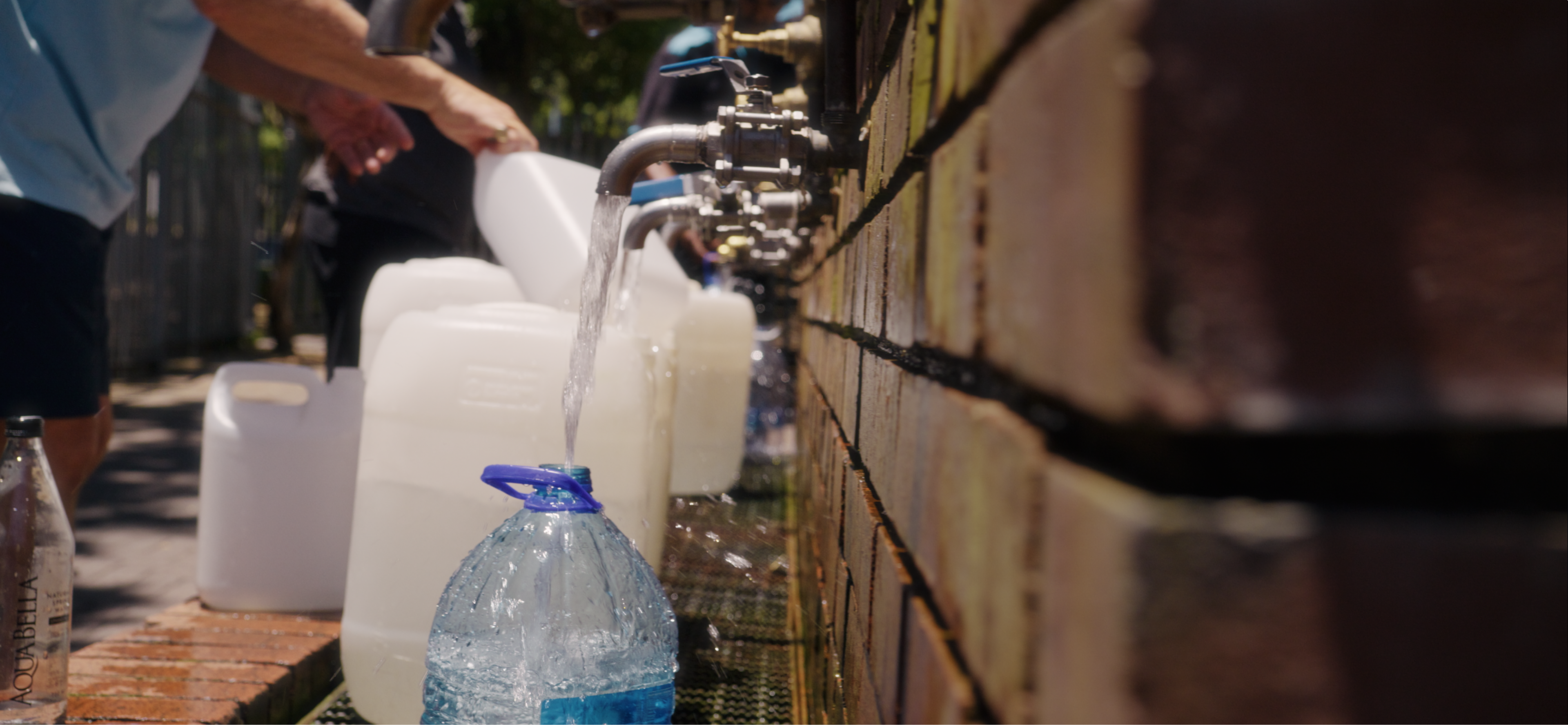 Containers being filled at water collection point in Capetown