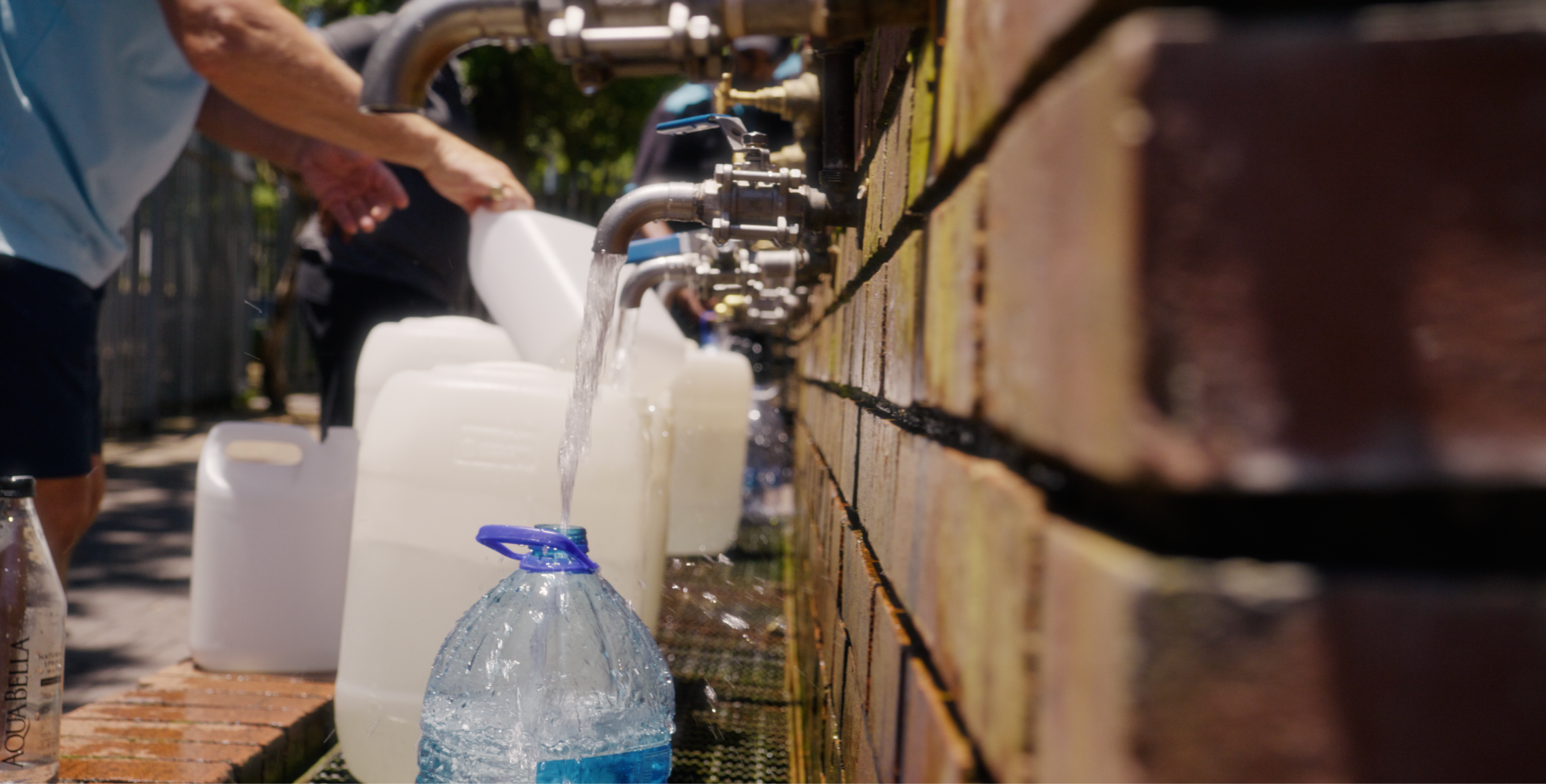 Close up of containers being filled at water collection point