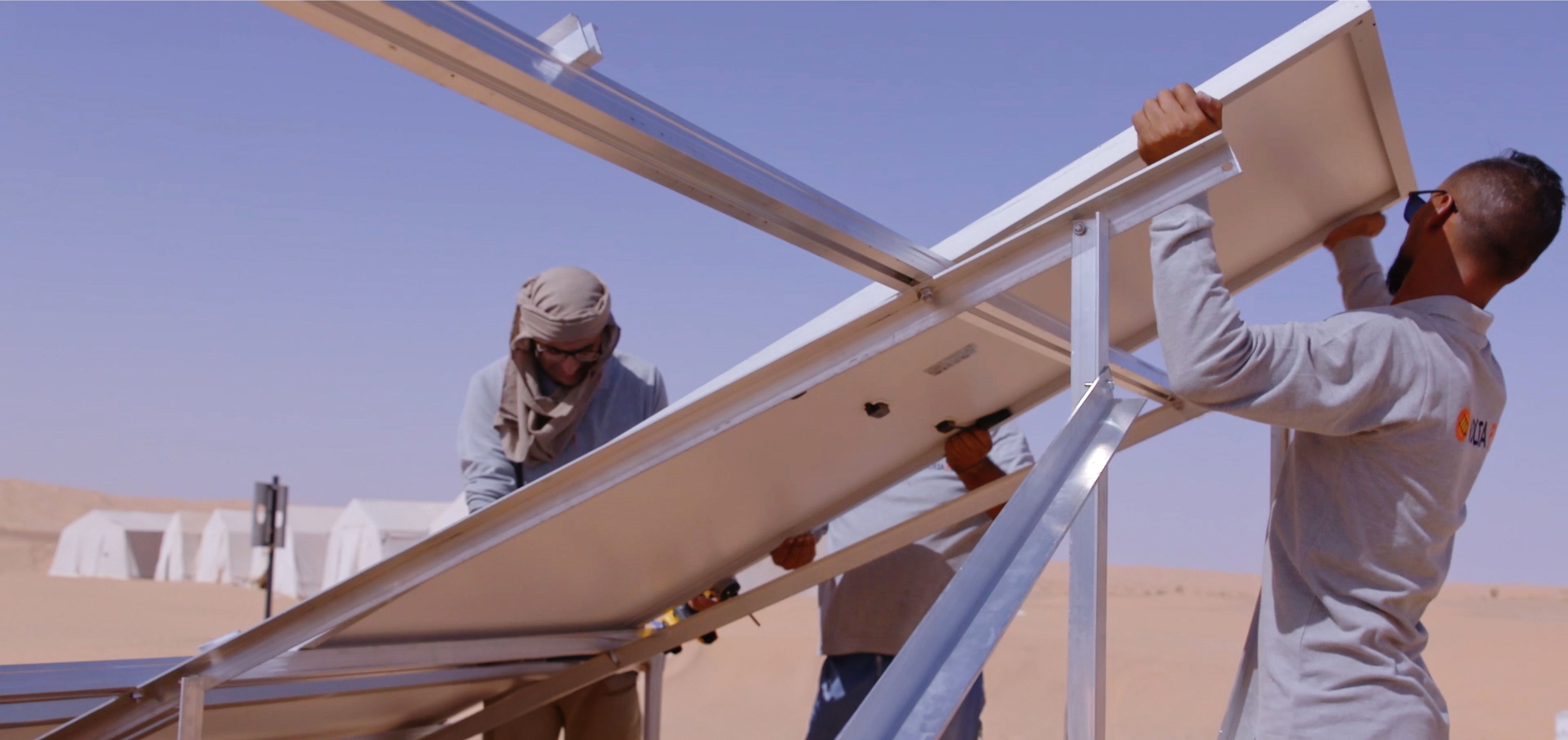 Workers building a solar panel for drinking water production.