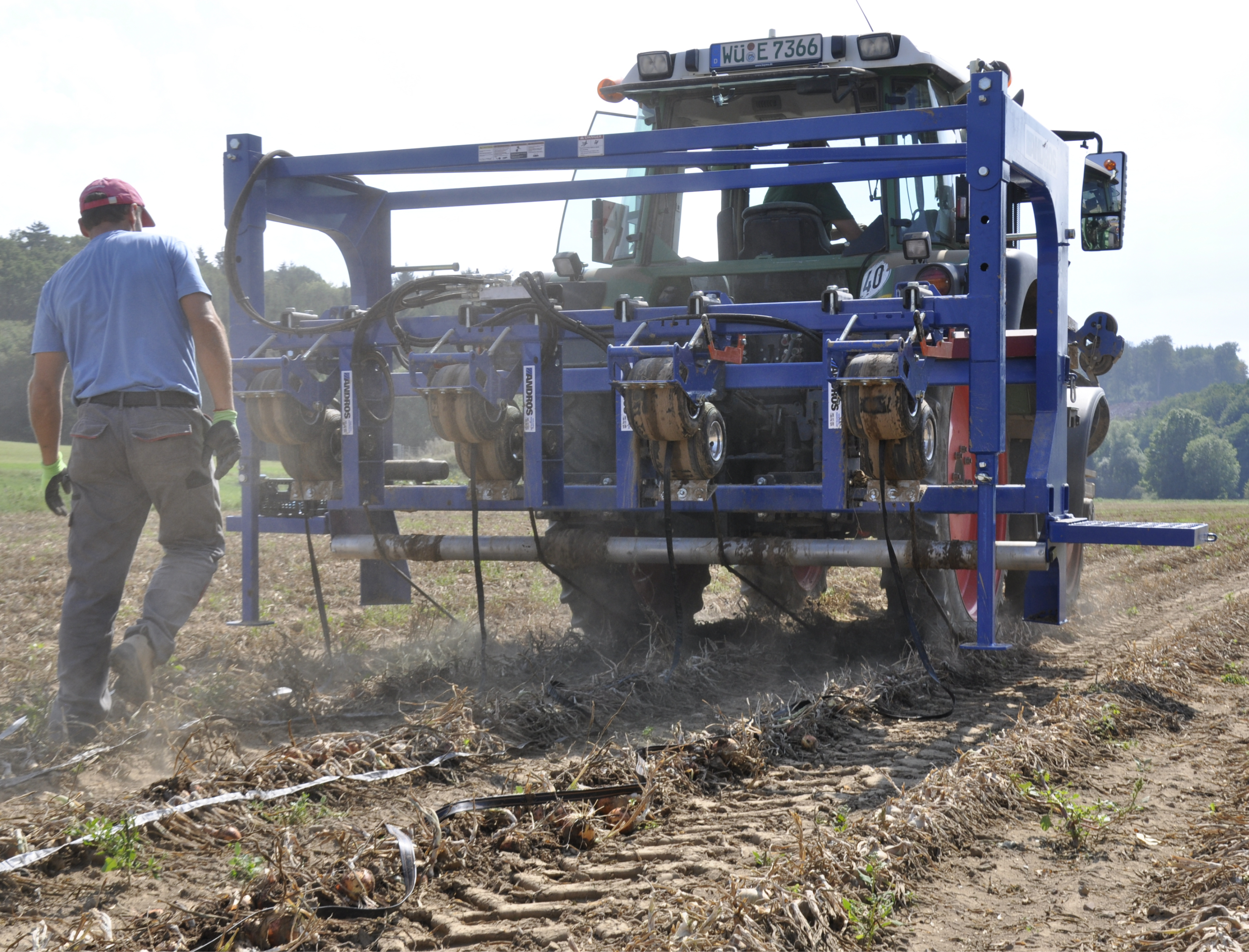 Backside of a tractor laying out watering hoses on field