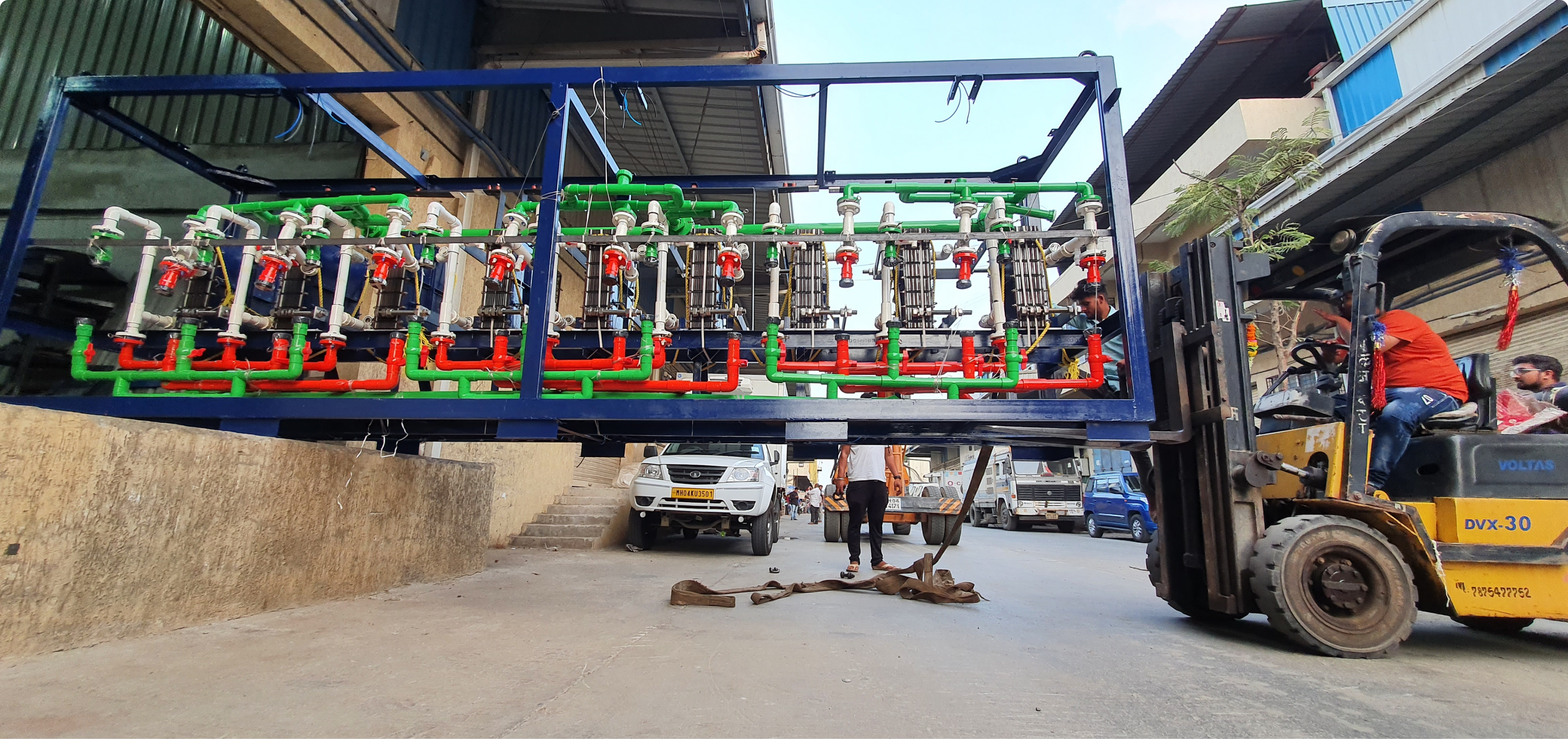 A fork lift picks up a water treatment modul with visible pipes