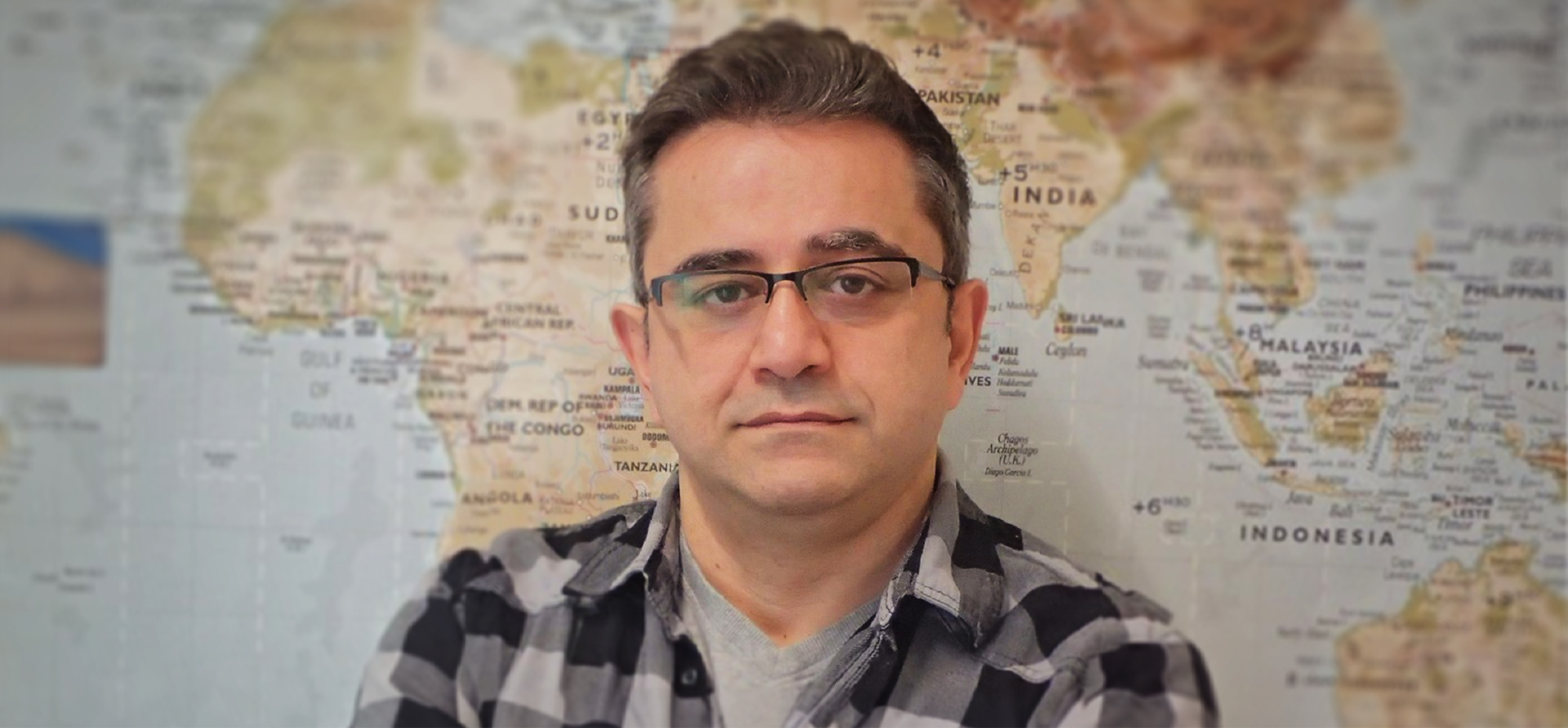 Portrait of Mohsen Makki in front of world map