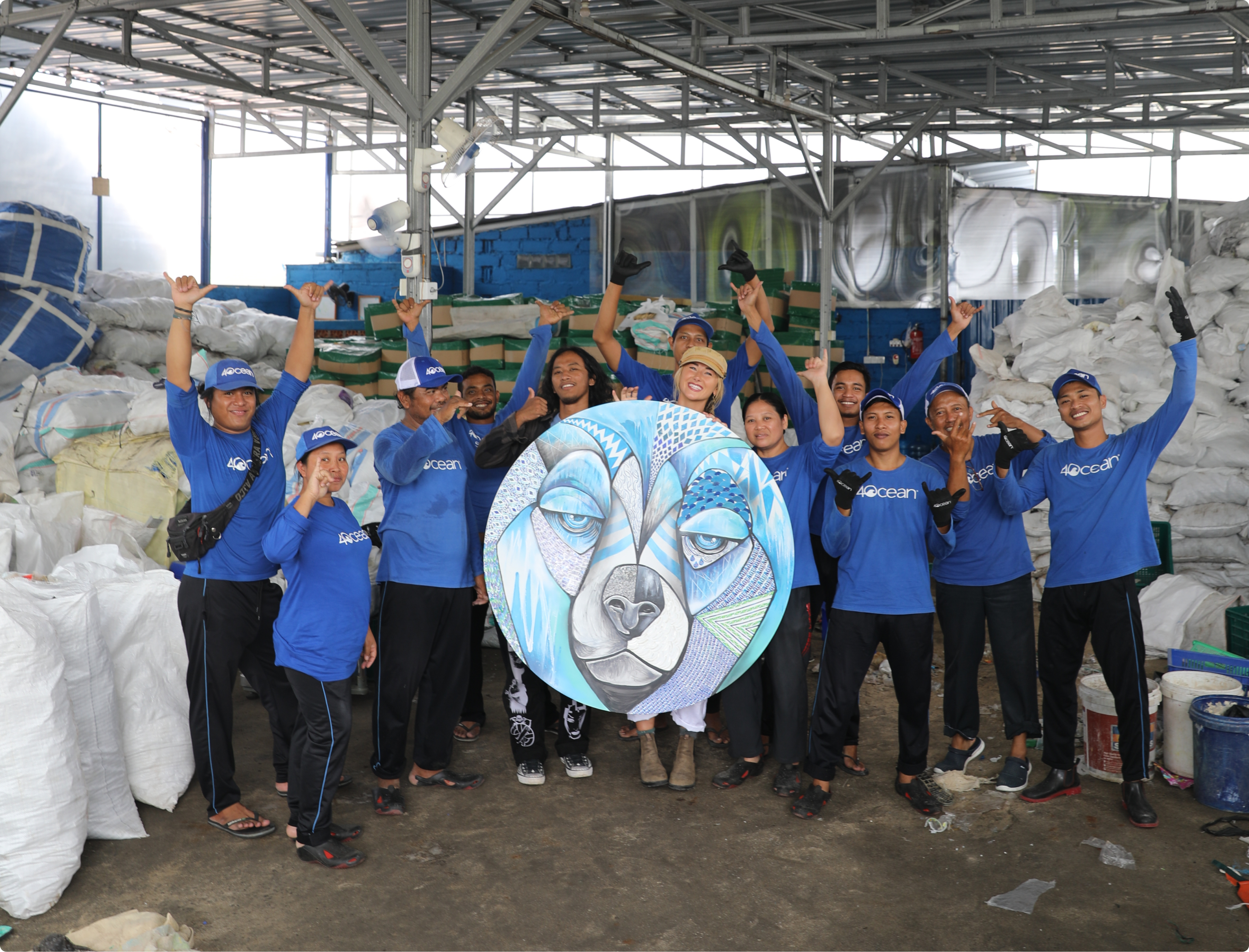 Group photo of 4ocean volunteers and in the middle is an artwork.
